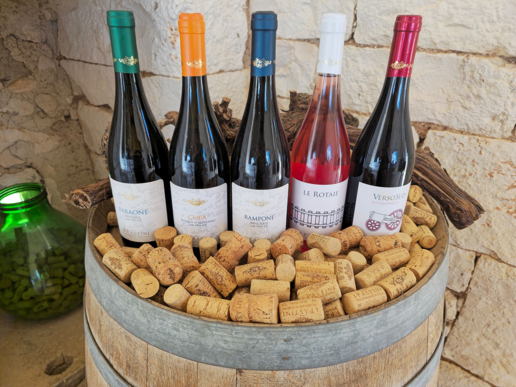 Botellas y barricas de vino con etiquetas de denominación de origen en una bodega española