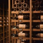 Botellas de vino con etiqueta en una bodega de guarda, con la añada visible en una de ellas
