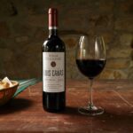Copa de vino blanco junto a viñedos de la región de La Rioja al atardecer