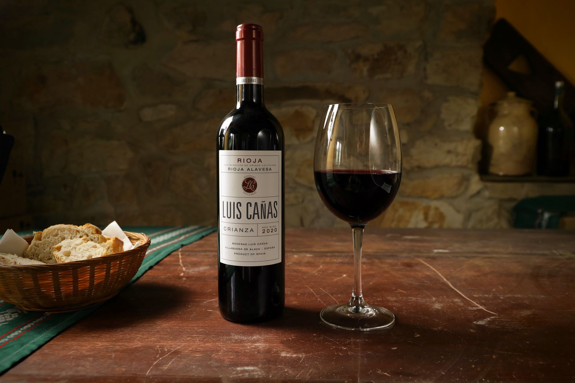 Copa de vino blanco junto a viñedos de la región de La Rioja al atardecer