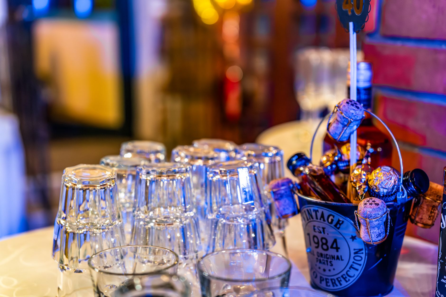 Botella de vino blanco enfriándose en una cubitera junto a dos copas sobre una mesa