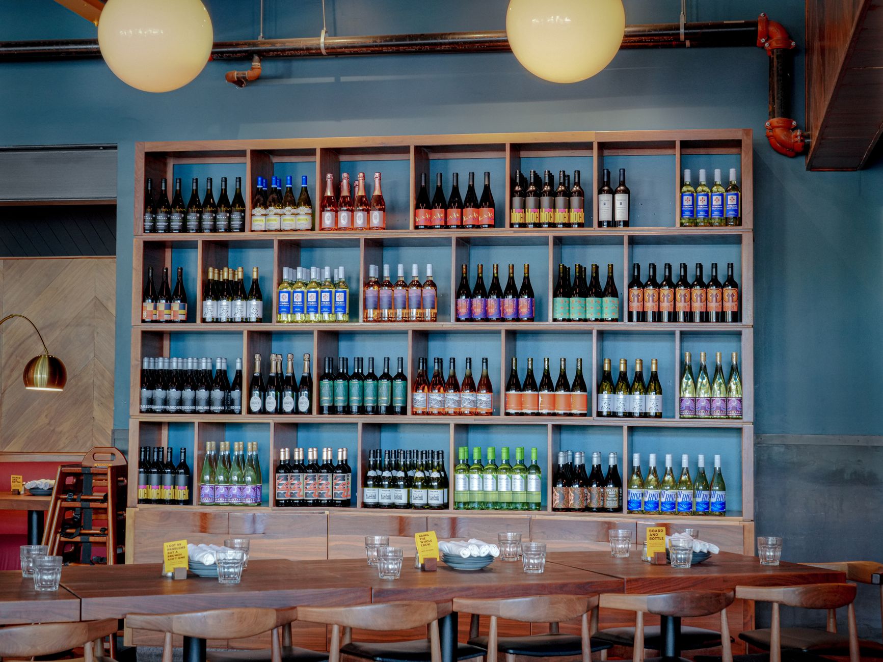 Varias botellas de vino sobre una mesa de madera junto a copas listas para una cata informal