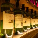Copa de vino y botellas en una bodega, con la etiqueta a la vista