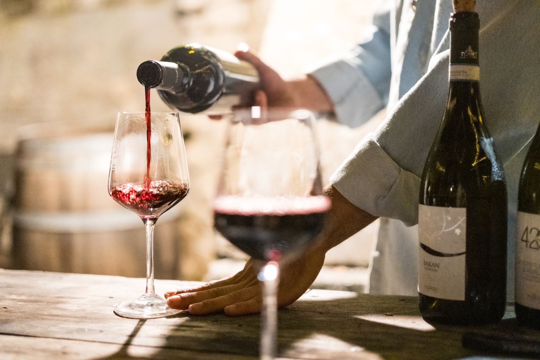 Persona observando el color de un vino tinto en una copa durante una cata
